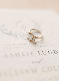 a closeup of an heirloom engagement ring on wedding stationery