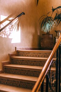 A small set of indoor hispanic clay sairs in a fancy home. The stairs have tile footers.