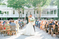 While holding his new bride’s colorful peony filled bouquet in one hand, the Groom twirls his bride in the other at a venue where The Iconic Notebook was filmed - Boone Hall! Captured by Kara Blakeman Photography, specializing in bright, romantic, joy-filled photography in Charleston, SC.