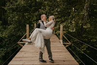 Groom carrying his bride on the creek