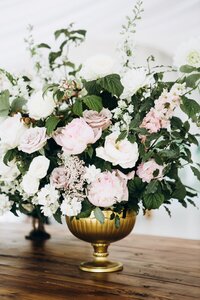 Wedding centerpiece in gold vase with pink and white flowers