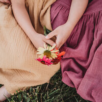 Family Photographer, a mother and daughter's hand share colored flowers