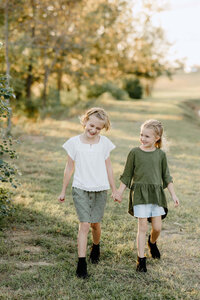 candid playful moment between two young sisters during family pictures