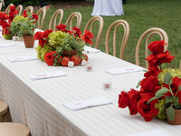 A spacious outdoor tent at Boxwood Estate, set up for a wedding with elegant decor. The tent is large enough to accommodate up to 350 guests, with long banquet tables arranged neatly underneath sparkling string lights. The open sides offer views of the surrounding lush greenery, and floral arrangements and candles add a romantic touch to the ambiance. The setting is both sophisticated and welcoming, perfect for a grand celebration.