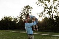 A candid, heartwarming moment between a father and son captured during golden hour by a New England family photographer. Set against the stunning natural backdrop of Vermont or Maine, this lifestyle photo showcases the genuine emotional bond between parent and child. Ideal for showcasing authentic outdoor family photography, this image highlights the beauty of golden hour light and the timelessness of family moments in scenic New England. Perfect for family portrait inspiration, blog features, or stock photography.