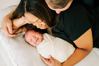 pregnant mom kneeling on floor during maternity photography session in Springfield MO in brown robe