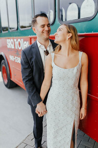 A picture of a bride looking back at her groom in front of a trolley 