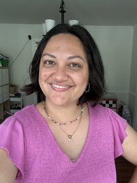 Woman smiling, wearing a pink t-shirt