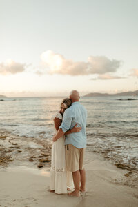 Engagement session featuring a couple embracing on the beach