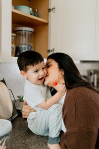 woman kissing baby and baby laughing