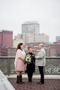 Raina officiating a ceremony on the pedestrian bridge in downtown Nashville at sunset