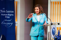 A woman waving while standing at a podium