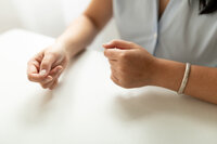 close up detail of woman sitting at desk gesturing with hands for branding session