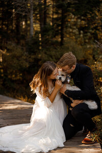 Couple kissing their dog during their elopement in New Hampshire