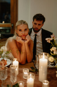 A couple joyfully runs through a desert landscape in Palm Springs, California, during their elopement. One partner wears a ruffled, strapless dress, while the other is dressed in a suit, both laughing as the wind blows through their hair.