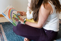 Mother reading to her toddler as she sits on her lap