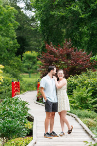 Candid garden engagement session at Acton Arboretum featuring natural greenery and emotion.