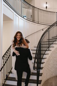 groom carrying bride up the stairs