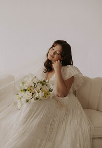 editorial bridal session in a studio in Lancaster PA with a bride holding her bouquet on a fancy couch
