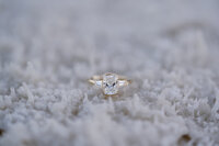 A close up of an engagement ring on salt