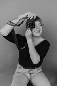 Philadelphia Photographer Heather McBride holding a camera and taking a photo.