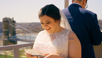 Bride and Groom reading letters to one another on rooftop of AC Marriott Hotel in Downtown Cincinnati