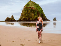 Woman in a black dress standing on Cannon Beach – powerful brand portrait for creatives by Mewphotovideo