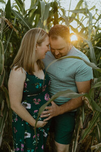 maternity session with husband and wife hugging each other in cord field