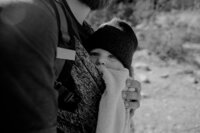 woman holding baby in carrier