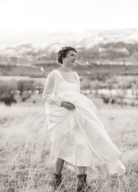 Bride laughing on windy mountain top