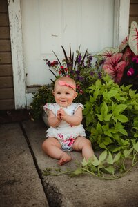 baby playing with flowers and in the dirt