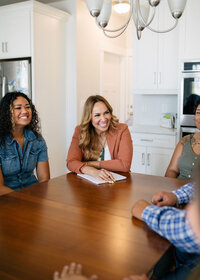 Therapist sitting at a table talking to a group of people