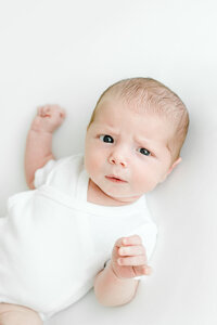 Newborn baby makes cute face during newborn photography session