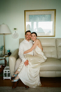 film photo of bride and groom sitting on the coach at their coast house by Lake Michigan