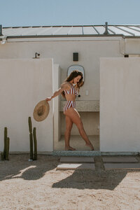 girl posing in bathroom in red striped bikini