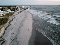 drone photo of a couple walking on the beach in brigantine nj