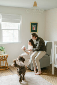 Philly couple in their nursery with their newborn and goldendoodle