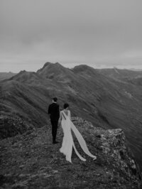 Bride and groom walk through the mountains