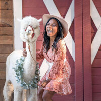 senior girl laughing histeruically while posing with an alpaca on a Powder Spring farm