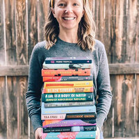 Sara of FictionMatters holding a stack of book recommendations