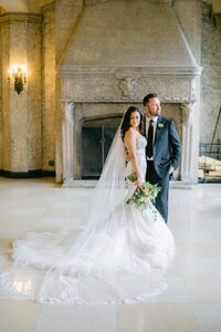 Bride and groom stand in front of the Banff Springs large windows for a portrait on their wedding day