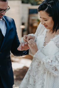 bride tying a promise ring during their wedding ceremony