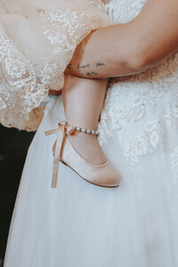 Baby's foot in a pink slipper with a bow