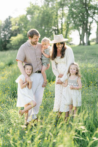 Philly mom and dad play with children in a field 