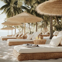 Beachfront lounge area with palm trees and oceanfront daybeds at tropical resort destination, perfect for honeymooners. Tailored Oasis Travel Co.