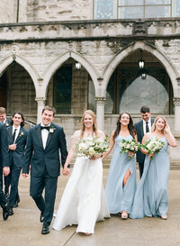 Bride and Groom  Holding Hands and Walking WIth Bridal Party Toward Camera Photo