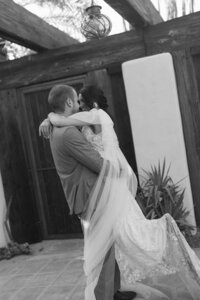 Black and white photo of newlyweds sharing a romantic dance at their destination wedding.