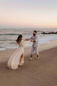a couples dancing together on the beach in a very romantic way