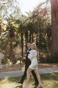 Film photo of bride and groom walking hand in hand at outdoor wedding venue in California by Erica Rochelle Photography northern california wedding photographers