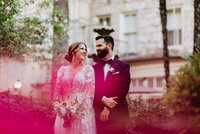 couple smiling at each other in courtyard with flowers